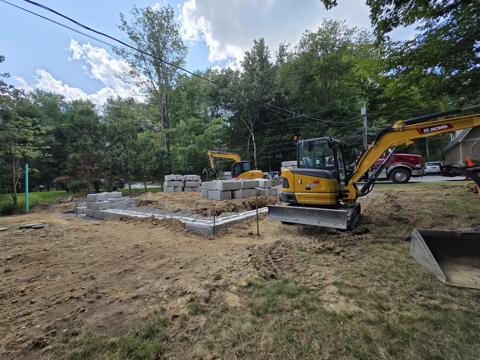 Blockwork in progress with compact excavators at the same residential site