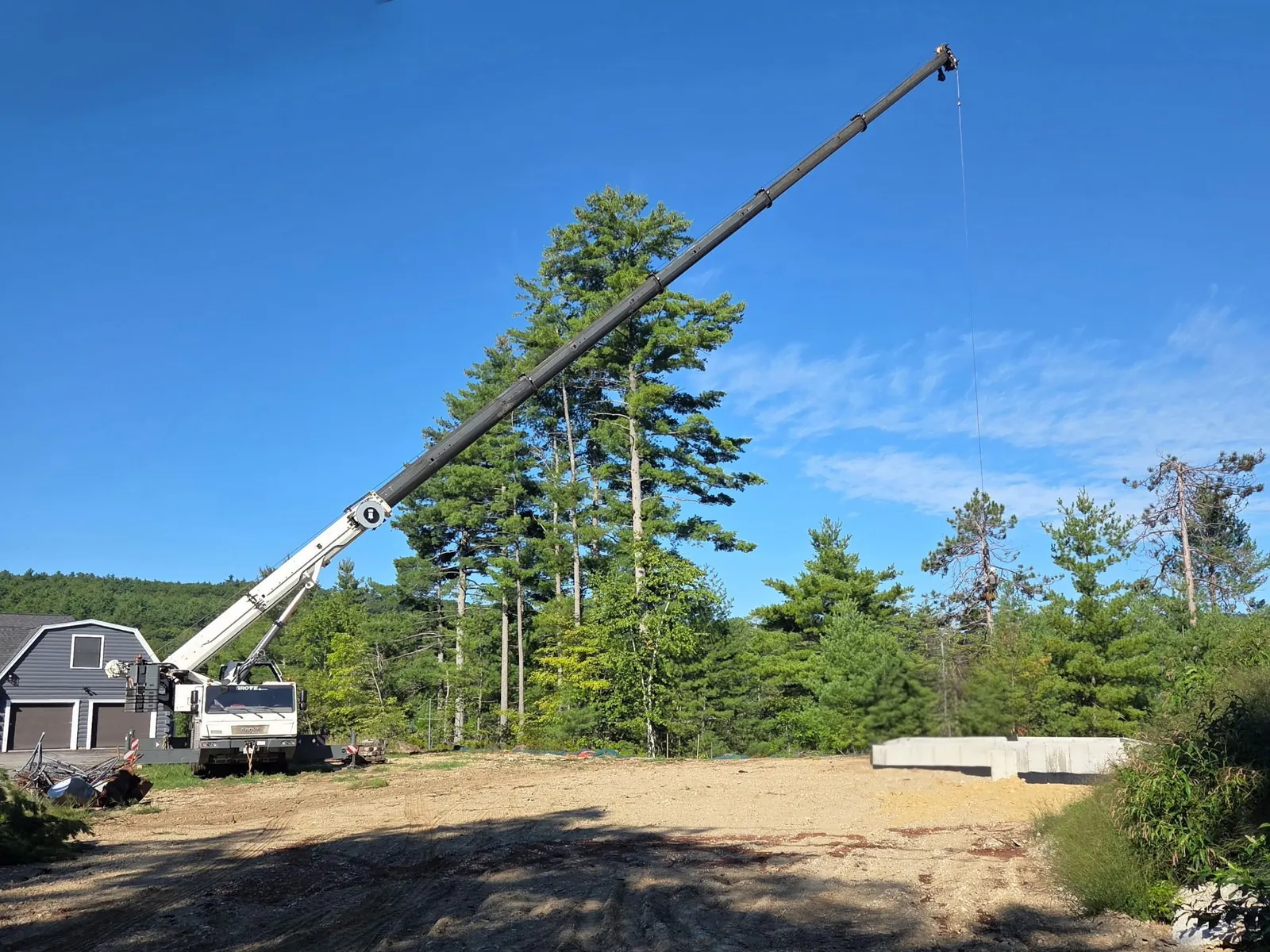 Timber Falls crane with its boom extended across an open residential jobsite