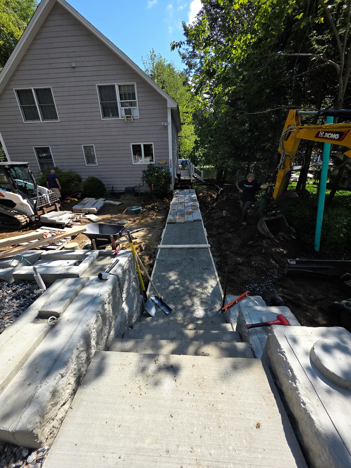Walkway installation underway beside a house