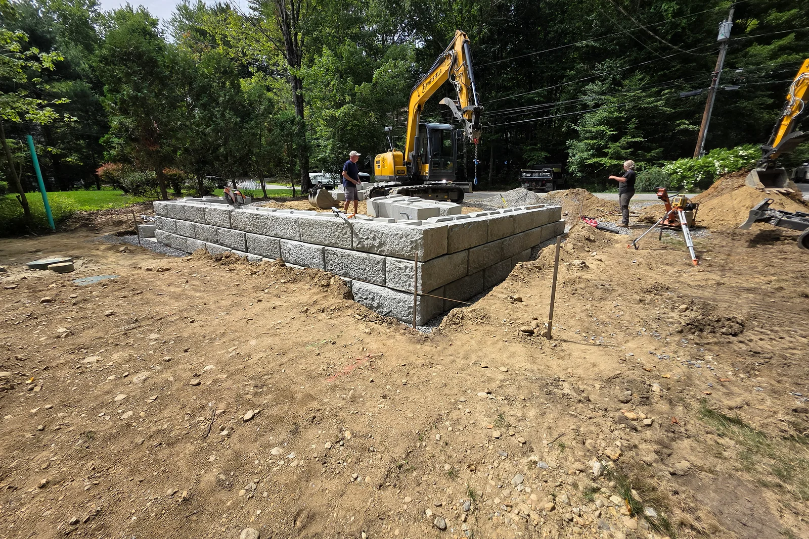 Block wall construction in progress with unfinished ground around it